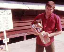 John Strain in front of the Camp USARTHAI PX with a recent purchase..